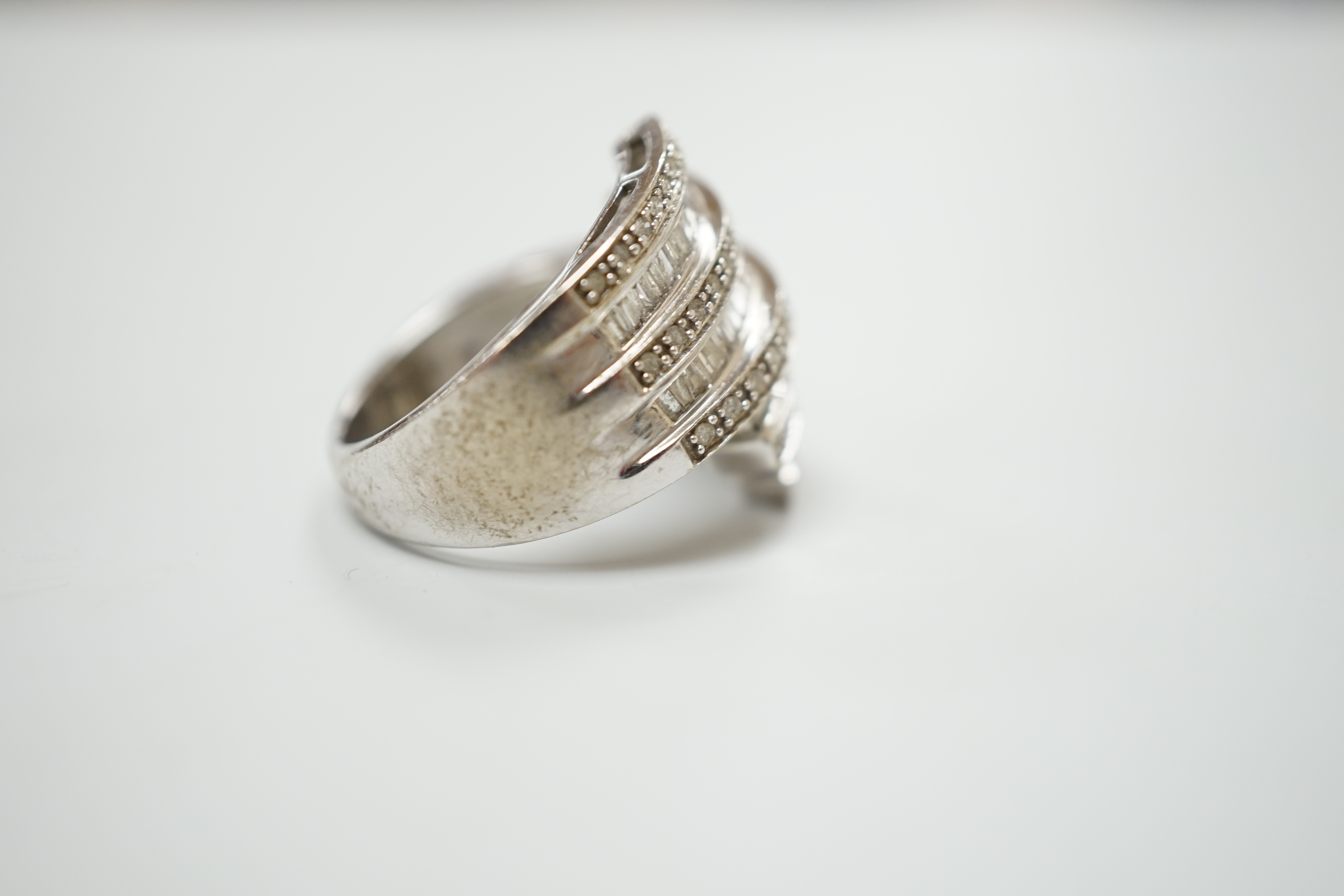 A 9ct white gold and dress ring designed with nine bands of brilliant and baguette cut stones, size N